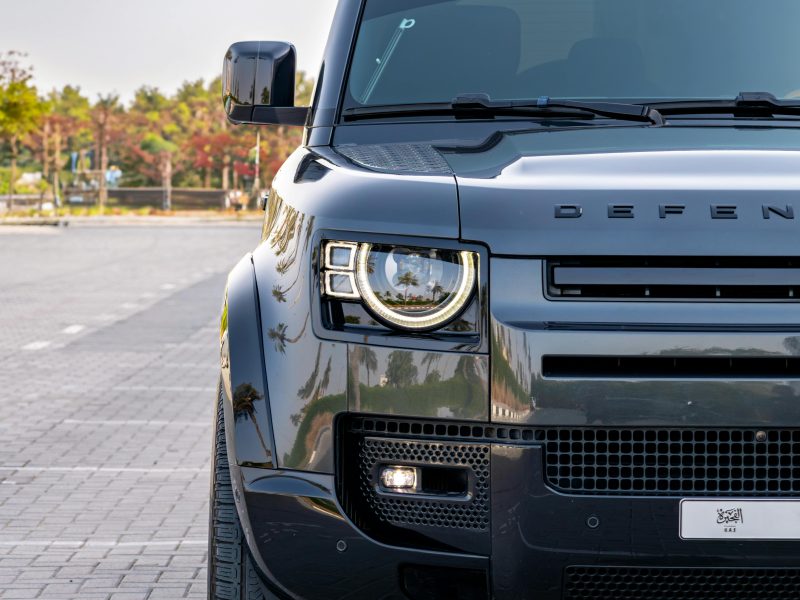 Front view of a modern Land Rover Defender parked in Dubai, highlighting its sleek design.